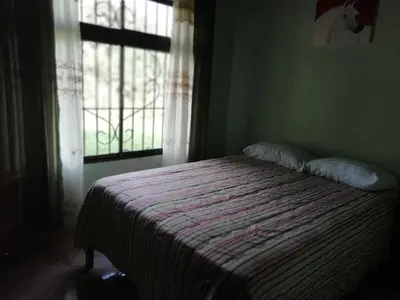a bed in a room with a window and a bedspread at Casas de Campo Las Pavitas Cottages 