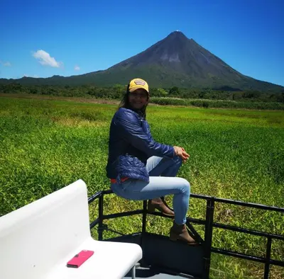a woman sitting on the back of a truck with a mountain in the background at Casas de Campo Las Pavitas Cottages 