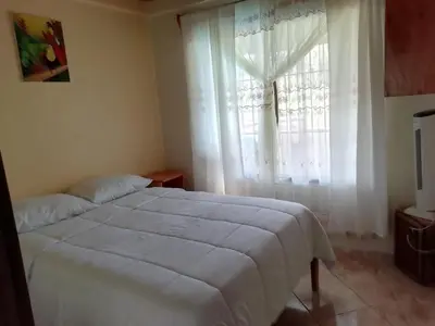 a bedroom with a white bed and a window at Casas de Campo Las Pavitas Cottages 