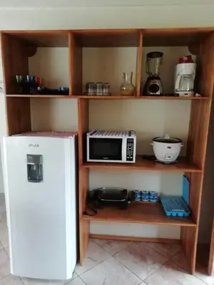 a microwave sitting on a shelf next to a refrigerator at Casas de Campo Las Pavitas Cottages 