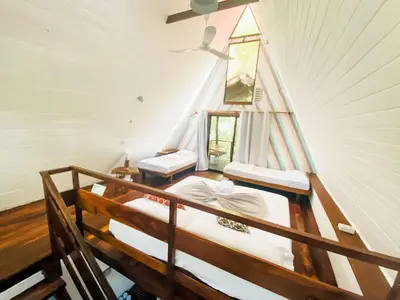 a room with two beds and a window in it at Calala Lodge in Cabuya