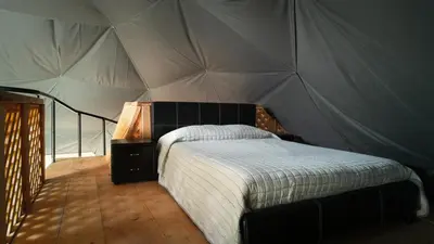 a bedroom with a bed in a tent at Altura Hotel in Poasito