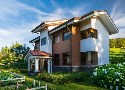 a house on a hill with a garden at Altura Hotel in Poasito