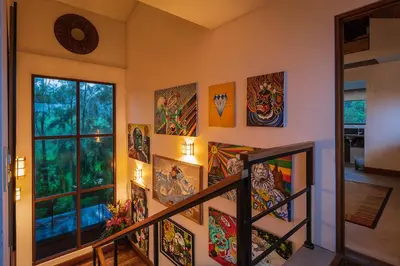 a staircase with paintings on the walls of a house at Altura Hotel in Poasito
