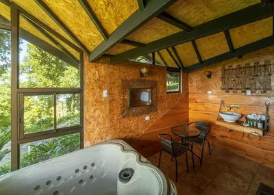 a bathroom with a tub and a table and a sink at Altura Hotel in Poasito