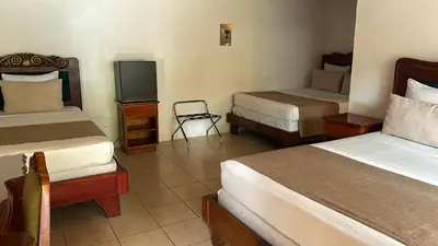 a hotel room with two beds and a television at Hotel Javy in Liberia