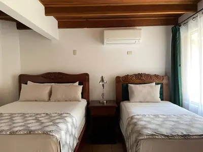 two beds sitting next to each other in a bedroom at Hotel Javy in Liberia