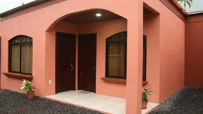 a pink house with a door and windows at Arenal Red in Fortuna