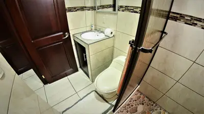 a small bathroom with a toilet and a sink at Arenal Red in Fortuna