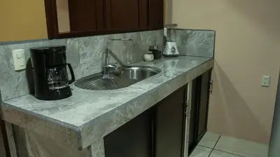 a kitchen counter with a sink and a coffee maker at Arenal Red in Fortuna