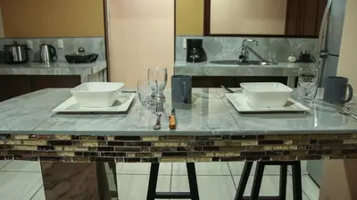 a table with two plates and glasses and a sink at Arenal Red in Fortuna