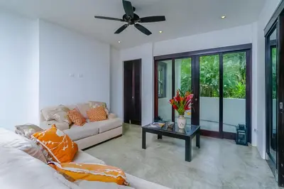 a living room with a couch and a ceiling fan at Makara Rio Suite / Ground Floor in Uvita