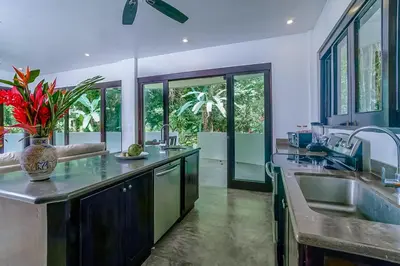 a large kitchen with a vase of flowers on the counter at Makara Rio Suite / Ground Floor in Uvita