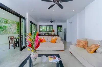 a living room with a white couch and a table at Makara Rio Suite / Ground Floor in Uvita