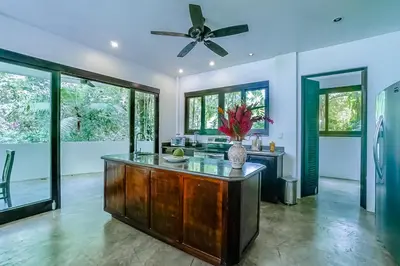 a kitchen with a center island with a ceiling fan at Makara Rio Suite / Ground Floor in Uvita