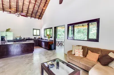 a living room with a couch and a table at Makara Suite Penthouse in Uvita