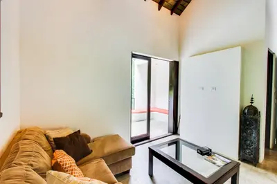 a living room with a couch and a glass table at Makara Suite Penthouse in Uvita