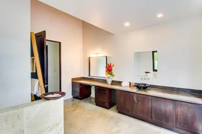 a bathroom with a counter with two sinks and mirrors at Makara Suite Penthouse in Uvita