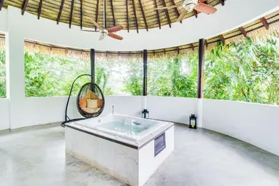 a bath tub in a room with large windows at Makara Suite Penthouse in Uvita