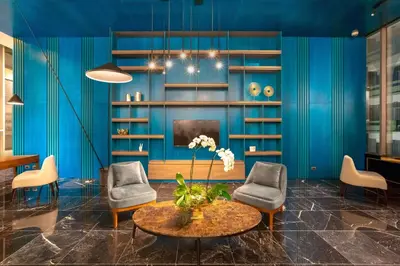 a living room with blue walls and a table and chairs at Gran Hotel Costa Rica, Curio Collection By Hilton in San José