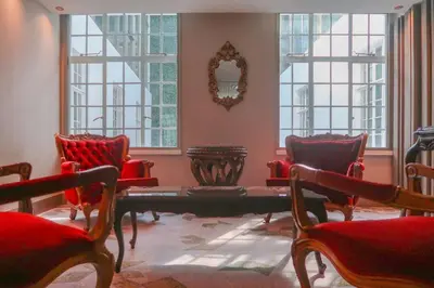 a room with chairs and a table and windows at Gran Hotel Costa Rica, Curio Collection By Hilton in San José