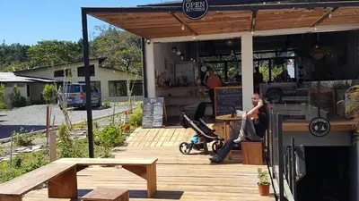 a man sitting at a table outside of a restaurant at OutBox Inn in Monteverde Costa Rica