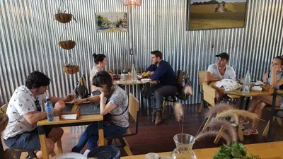 a group of people sitting at tables in a restaurant at OutBox Inn in Monteverde Costa Rica
