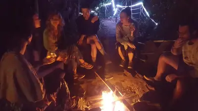 a group of people sitting around a fire at OutBox Inn in Monteverde Costa Rica