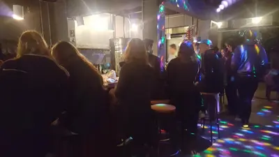 a group of people sitting in a bar at night at OutBox Inn in Monteverde Costa Rica
