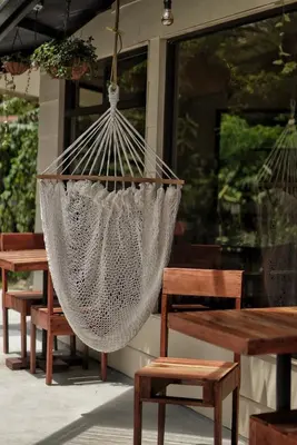 a hammock hanging from a porch with wooden benches at OutBox Inn in Monteverde Costa Rica