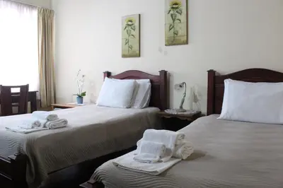 a bedroom with two beds with towels on them at Casa Mora B&B in Cartago