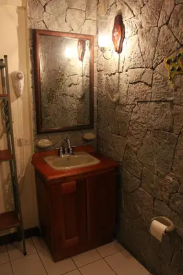 a bathroom with a sink and a stone wall at Casa Mora B&B in Cartago