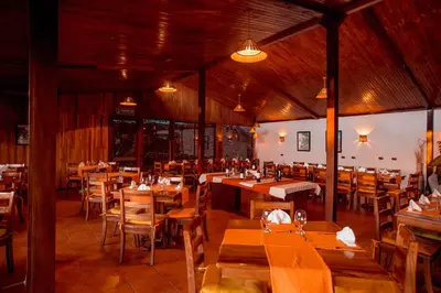 a dining room with wooden tables and chairs at Monteverde Country Lodge - Costa Rica in Monteverde Costa Rica