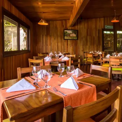a dining room with tables and chairs with wine glasses at Monteverde Country Lodge - Costa Rica in Monteverde Costa Rica