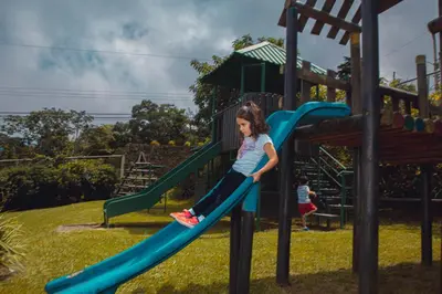 a young girl on a slide at a playground at Monteverde Country Lodge - Costa Rica in Monteverde Costa Rica