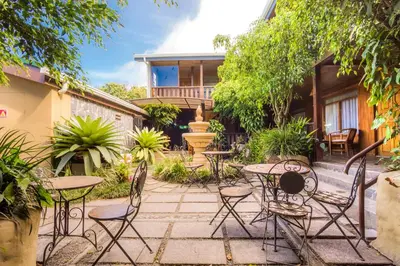 a patio with tables and chairs in front of a house at Monteverde Country Lodge - Costa Rica in Monteverde Costa Rica