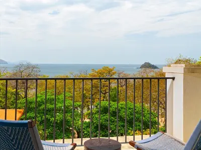 a balcony with chairs and a view of the ocean at Santarena Hotel at Las Catalinas in Playa Flamingo