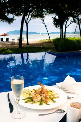 a plate of food on a table with a glass of wine at Jet Luxury at Langosta Beach Resort & Villas in Tamarindo