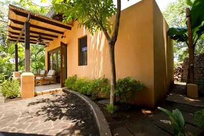 a house with a patio with a tree next to it at Jet Luxury at Langosta Beach Resort & Villas in Tamarindo
