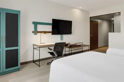 a bedroom with a bed and a desk with a television at Courtyard by Marriott San Jose Airport Alajuela in Alajuela City