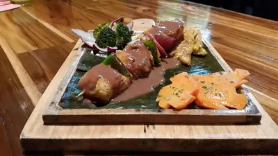 a plate of food with meat and vegetables on a table at Celeste Mountain Lodge in Bijagua