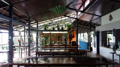 a restaurant with wooden tables and potted plants at Celeste Mountain Lodge in Bijagua