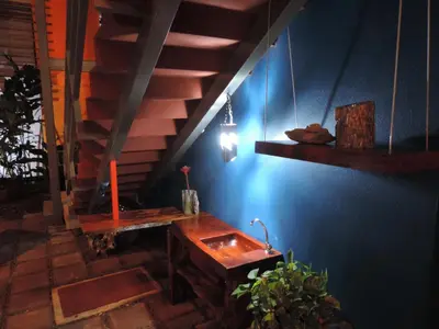 a room with a wooden table and a staircase at Celeste Mountain Lodge in Bijagua