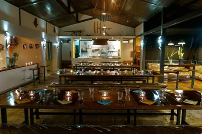 a restaurant with wooden tables in a room at Celeste Mountain Lodge in Bijagua