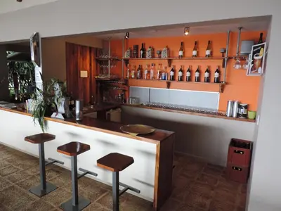a bar with stools in front of a counter at Celeste Mountain Lodge in Bijagua