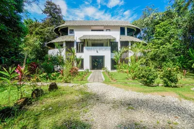 a large white house with a driveway at Makara Toucan Suite / 2nd Floor in Uvita