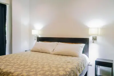a bedroom with a bed with two lamps on the wall at Makara Toucan Suite / 2nd Floor in Uvita