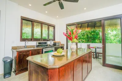 a kitchen with wooden cabinets and a counter top at Makara Toucan Suite / 2nd Floor in Uvita