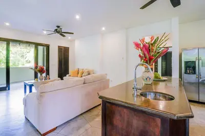 a kitchen and living room with a couch and a sink at Makara Toucan Suite / 2nd Floor in Uvita
