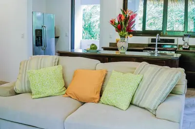 a couch with pillows on it in a living room at Makara Toucan Suite / 2nd Floor in Uvita